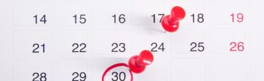 un calendrier sur lequel sont épinglés des boutons-poussoirs rouges