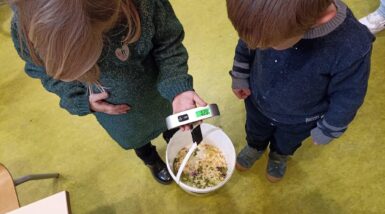 Deux enfants réalisant une pesée de restes de repas